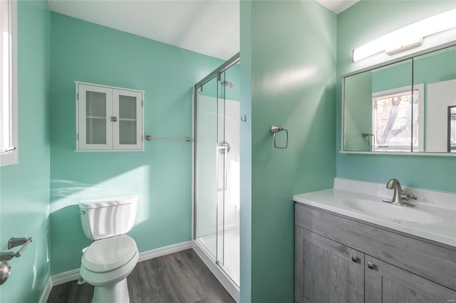 bathroom featuring a shower with door, vanity, hardwood / wood-style flooring, and toilet