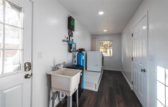 laundry area with sink, dark wood-type flooring, and washer / clothes dryer