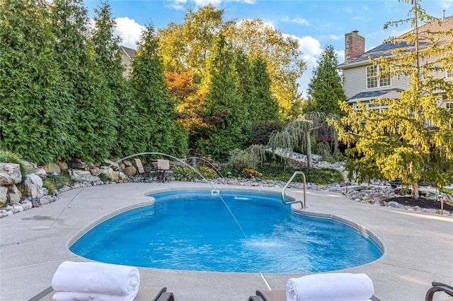 view of pool featuring pool water feature and a patio