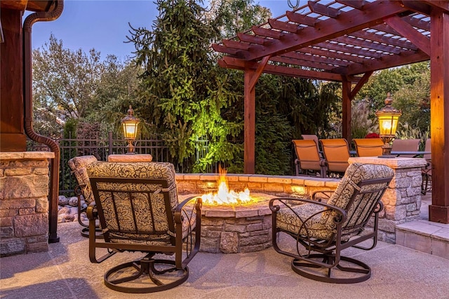 patio terrace at dusk featuring a pergola and a fire pit