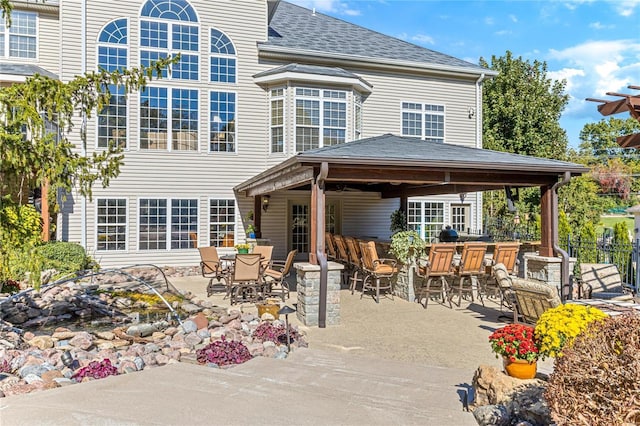 back of property featuring a patio, a gazebo, and an outdoor bar