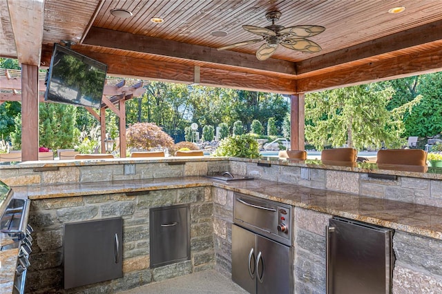 view of patio / terrace with ceiling fan and exterior kitchen