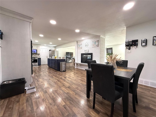 dining room with dark hardwood / wood-style floors and a fireplace