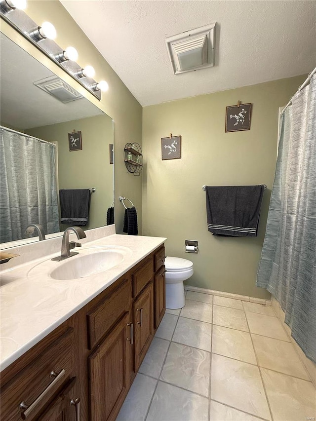 bathroom featuring a textured ceiling, toilet, vanity, and tile patterned flooring