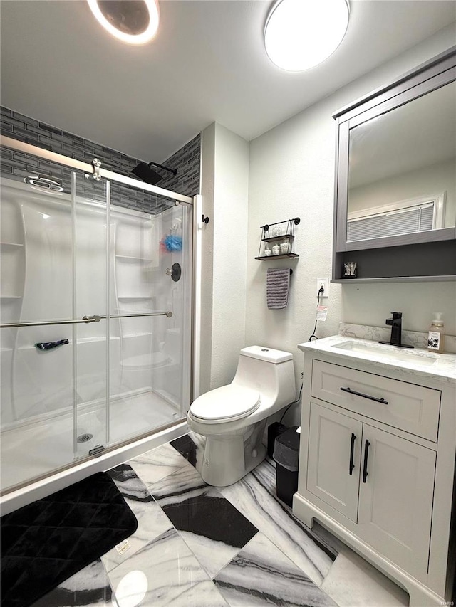 bathroom with toilet, vanity, and a shower with door