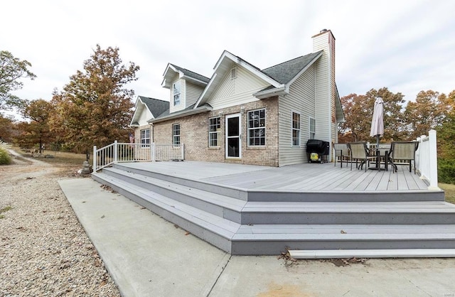 rear view of property featuring a wooden deck