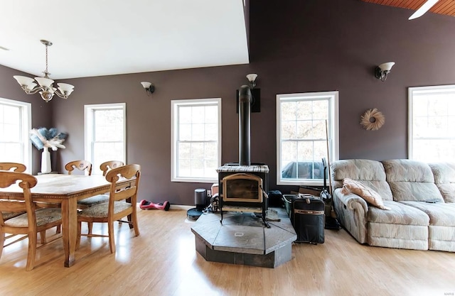 living room with a wood stove, a notable chandelier, and light wood-type flooring