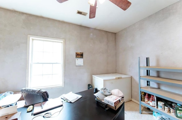 carpeted home office featuring ceiling fan