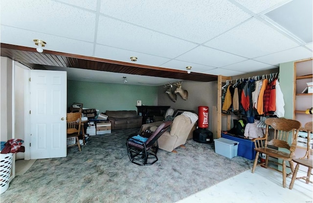 carpeted living room with a paneled ceiling