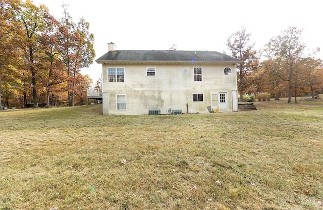 rear view of house with a lawn and central AC unit