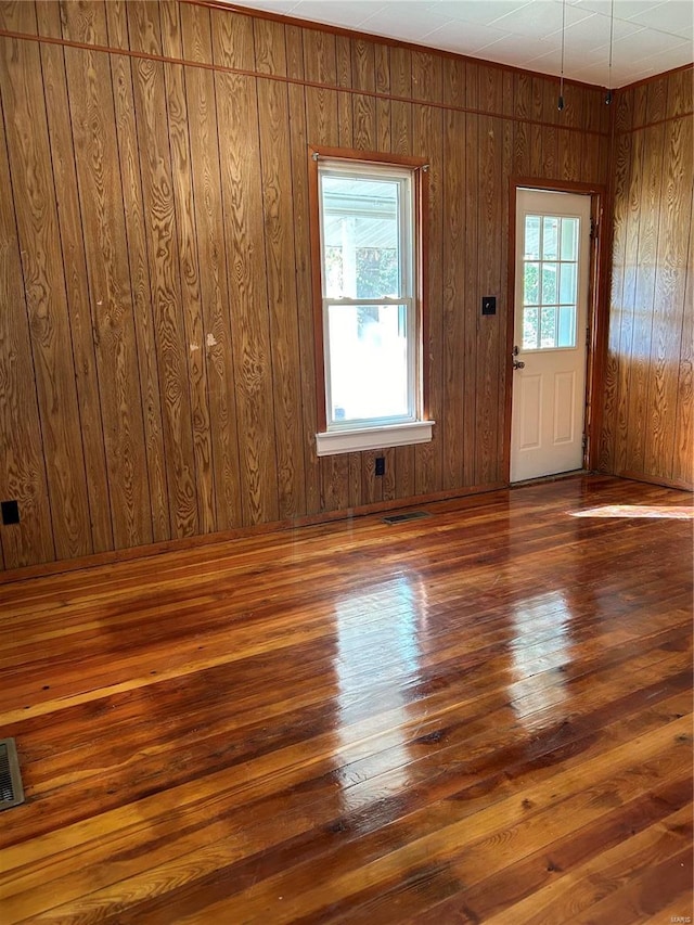 unfurnished room featuring wood walls and dark hardwood / wood-style flooring