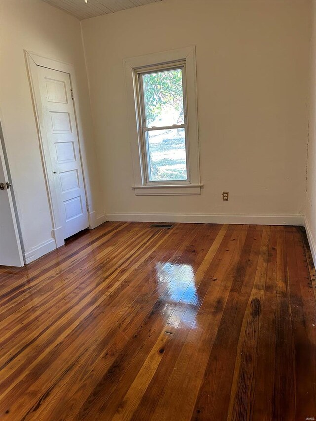 empty room with dark hardwood / wood-style flooring