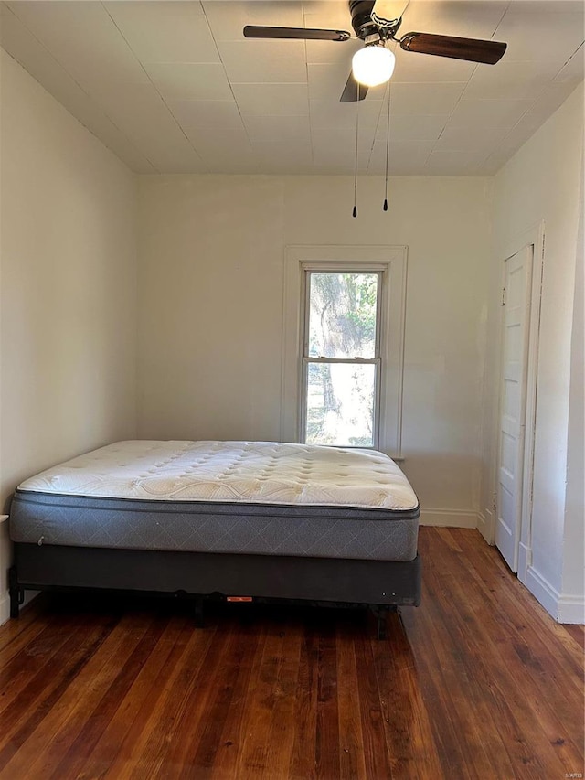 unfurnished bedroom with ceiling fan and dark hardwood / wood-style floors