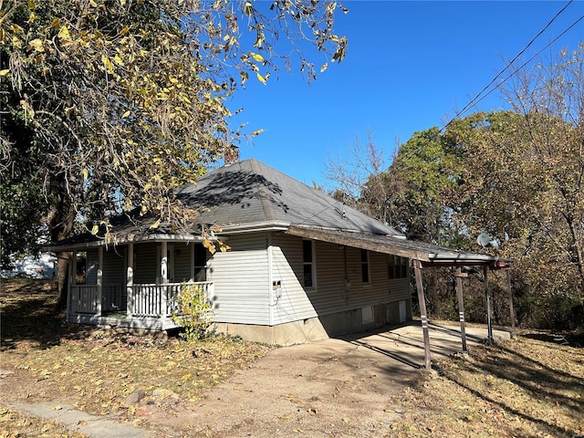 view of property exterior featuring covered porch and a carport