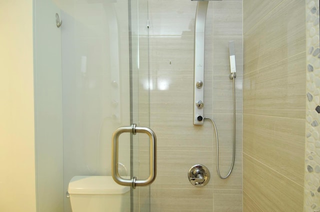 bathroom with toilet and a shower with shower door