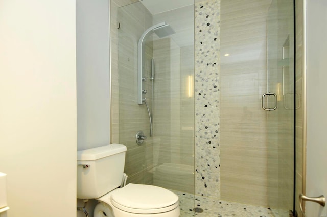 bathroom with toilet and a shower with door