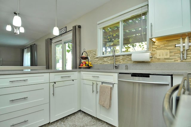 kitchen with decorative backsplash, white cabinetry, stainless steel dishwasher, sink, and decorative light fixtures