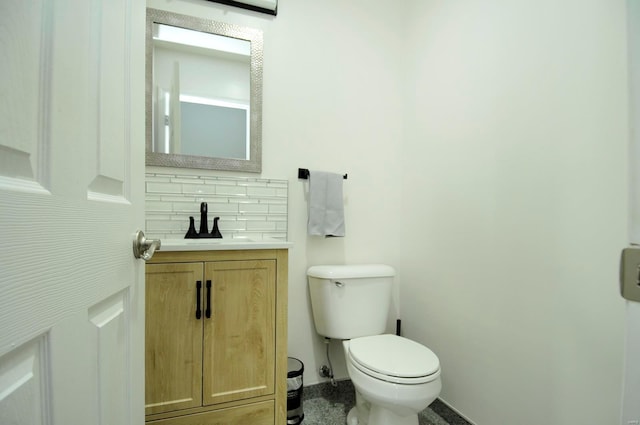 bathroom with toilet, decorative backsplash, and vanity