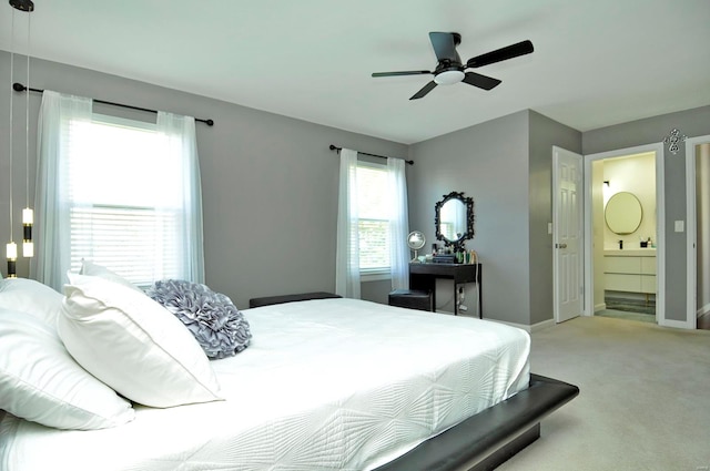 bedroom with connected bathroom, ceiling fan, and light carpet