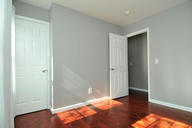 unfurnished bedroom featuring a closet and dark hardwood / wood-style floors