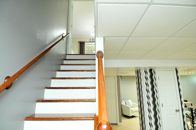 staircase featuring a paneled ceiling