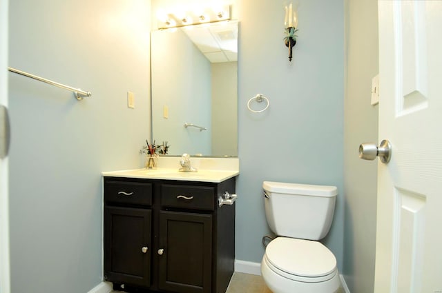 bathroom with toilet, vanity, and tile patterned floors