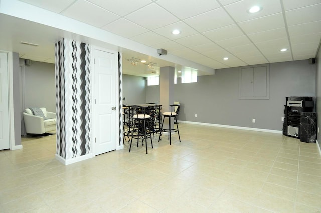 dining area with light tile patterned floors and a drop ceiling