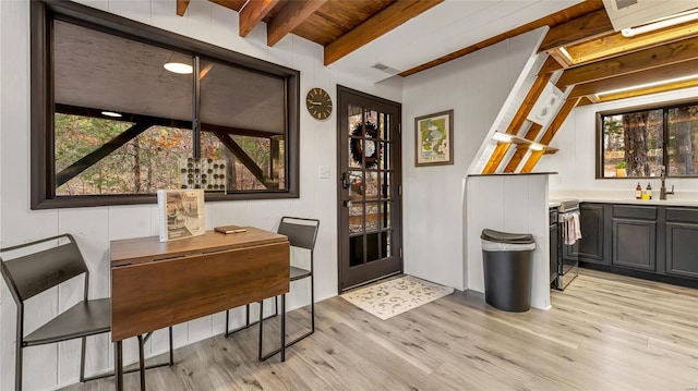 bar featuring wooden ceiling, light hardwood / wood-style floors, beamed ceiling, and plenty of natural light