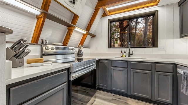 kitchen featuring gray cabinets, sink, lofted ceiling with beams, and stainless steel appliances