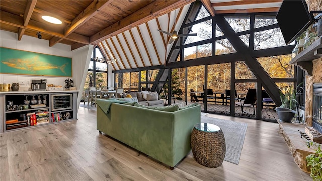 living room with beamed ceiling, hardwood / wood-style floors, high vaulted ceiling, and a healthy amount of sunlight