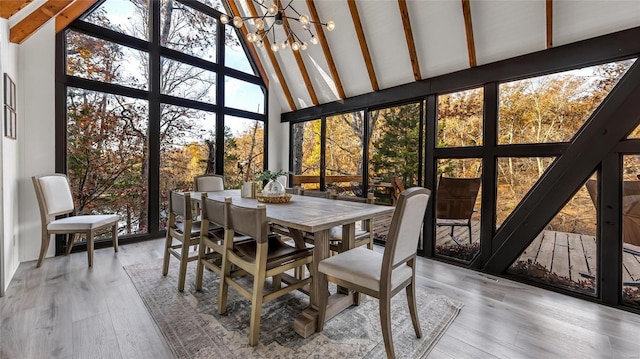 sunroom featuring a notable chandelier and lofted ceiling with beams