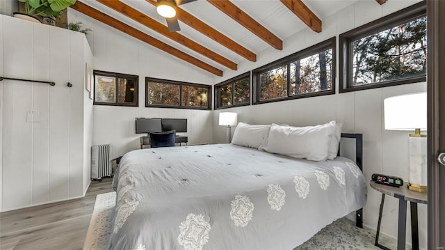 bedroom with light hardwood / wood-style floors, radiator, beamed ceiling, high vaulted ceiling, and ceiling fan