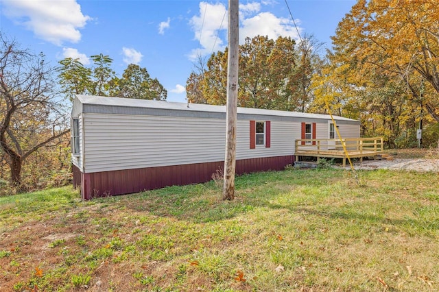 view of front of property featuring a front yard and a deck