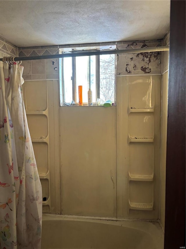 bathroom with shower / bath combo and a textured ceiling