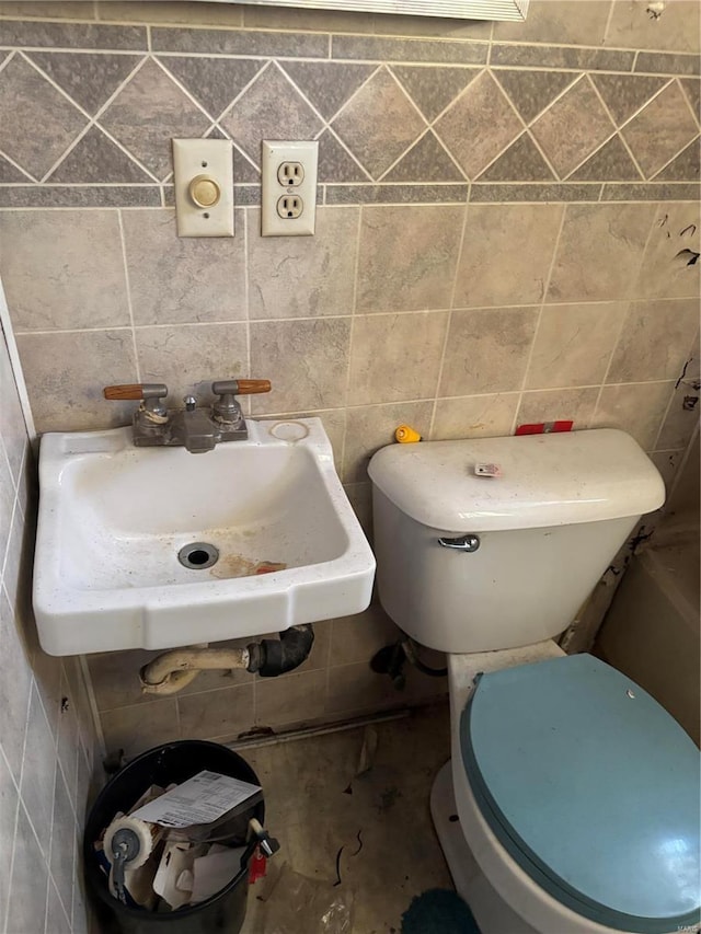 bathroom featuring sink and tile walls