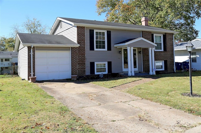 raised ranch with a front lawn and a garage