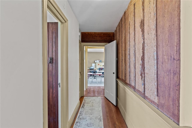 hall featuring hardwood / wood-style floors and wooden walls