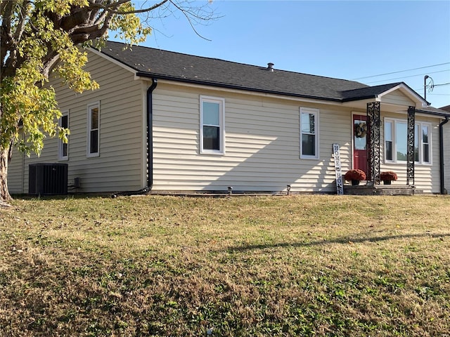 view of front of property featuring a front yard and central AC unit