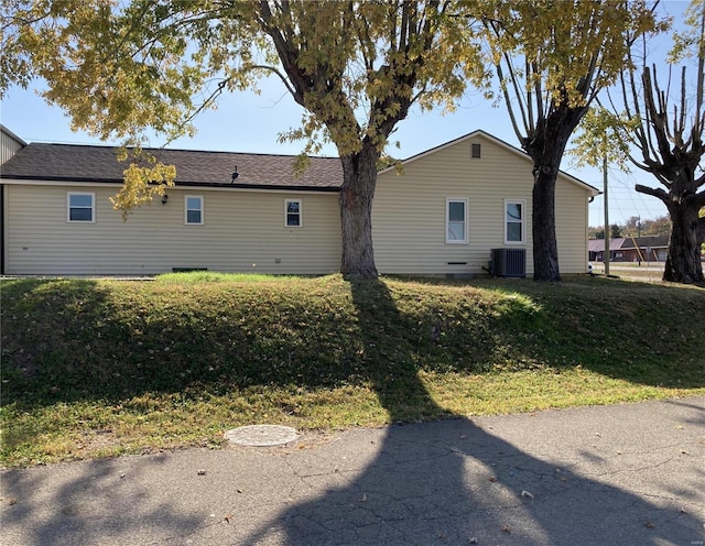 view of property exterior with cooling unit and a lawn