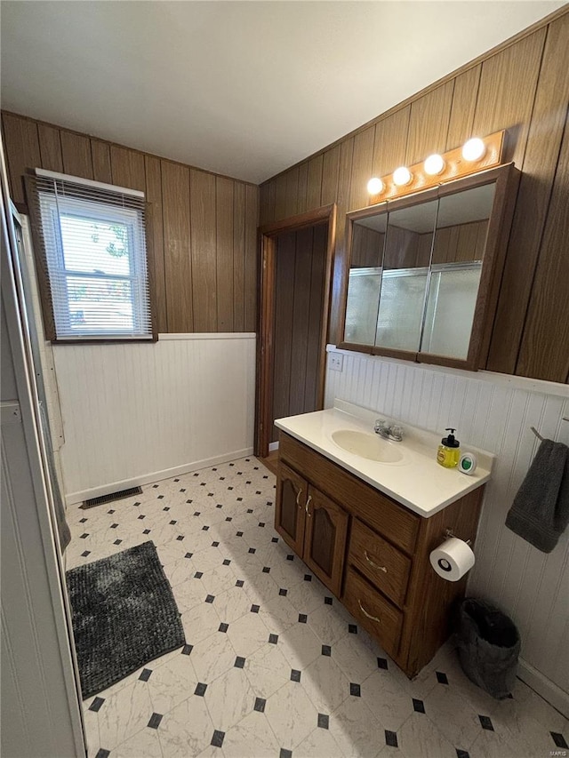 bathroom with vanity and wooden walls