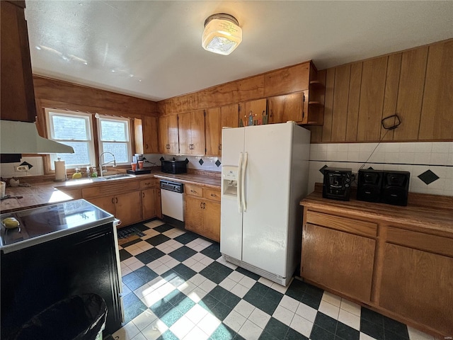 kitchen with white fridge with ice dispenser, range with electric cooktop, sink, backsplash, and stainless steel dishwasher