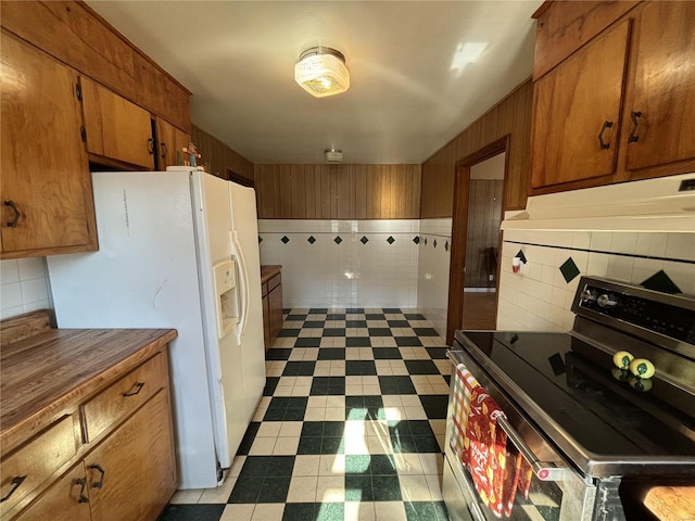 kitchen with tasteful backsplash, white refrigerator with ice dispenser, and electric stove