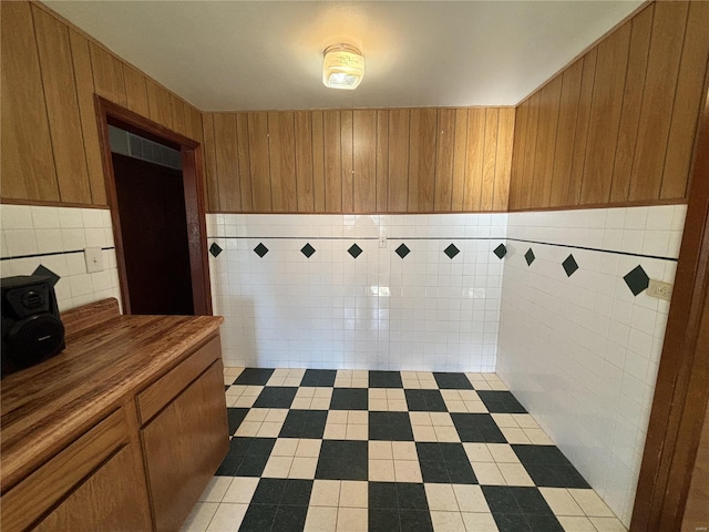 interior space featuring wood walls and tile walls