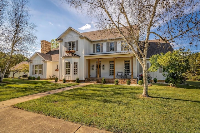 view of front of property featuring covered porch and a front yard