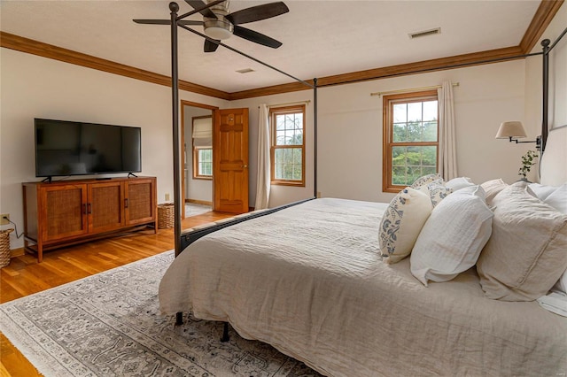 bedroom with crown molding, light wood-type flooring, and ceiling fan