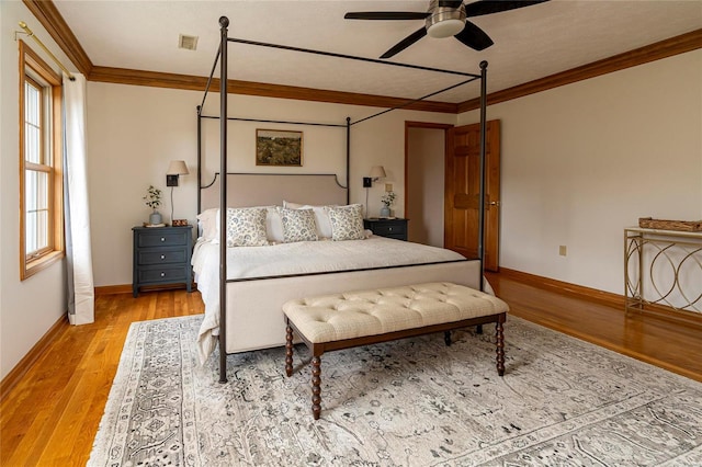 bedroom featuring crown molding, light hardwood / wood-style flooring, and ceiling fan