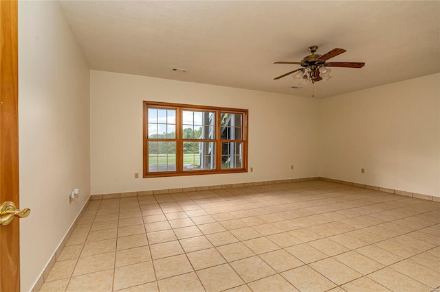 spare room with ceiling fan, a textured ceiling, and light tile patterned floors