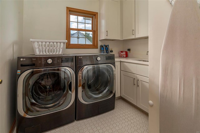 washroom with sink, washer and dryer, and cabinets