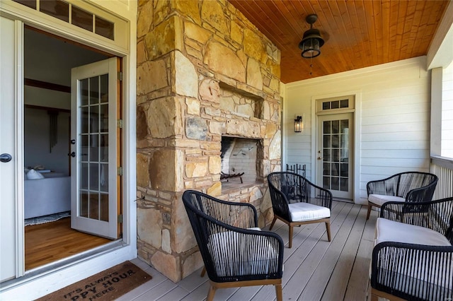 deck with an outdoor stone fireplace