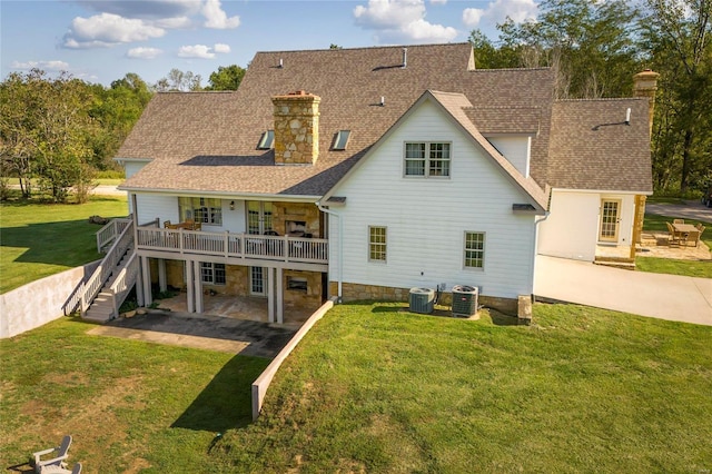 back of house featuring central AC, a patio, and a lawn